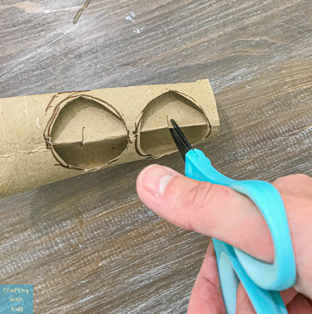 cutting holes in the toilet paper tube