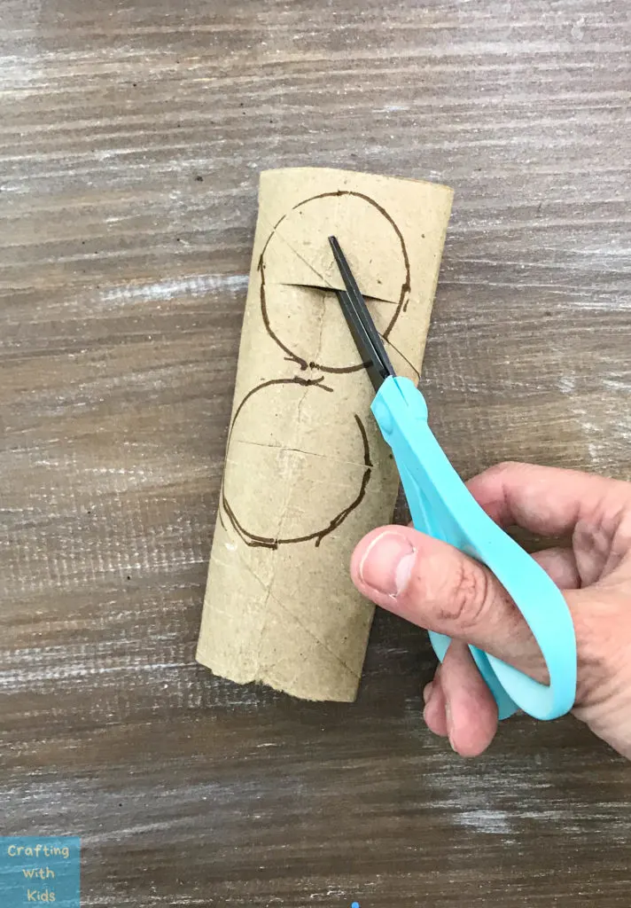 cutting two circles out of the toilet paper tube