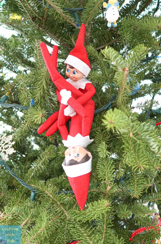 two elf on the shelf's playing in Christmas tree