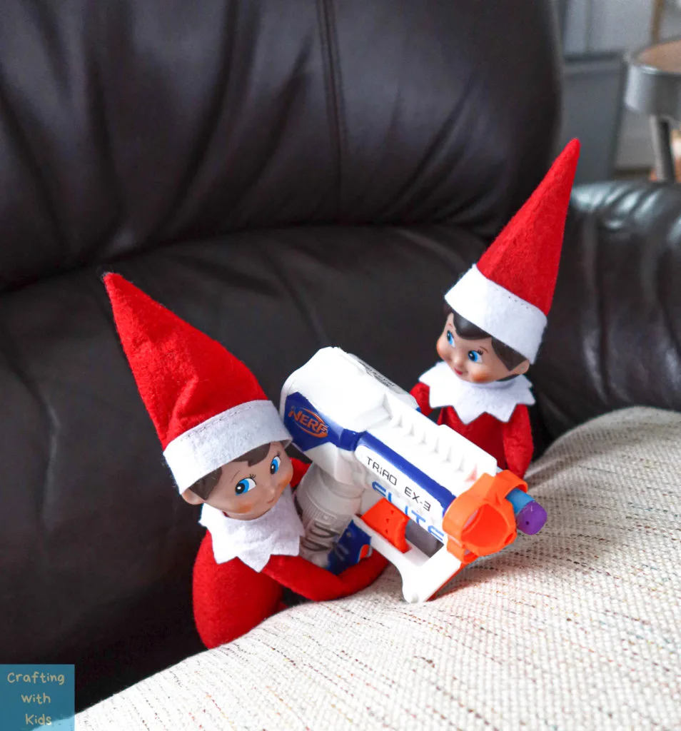 two elf on the shelf's with nerf guns 