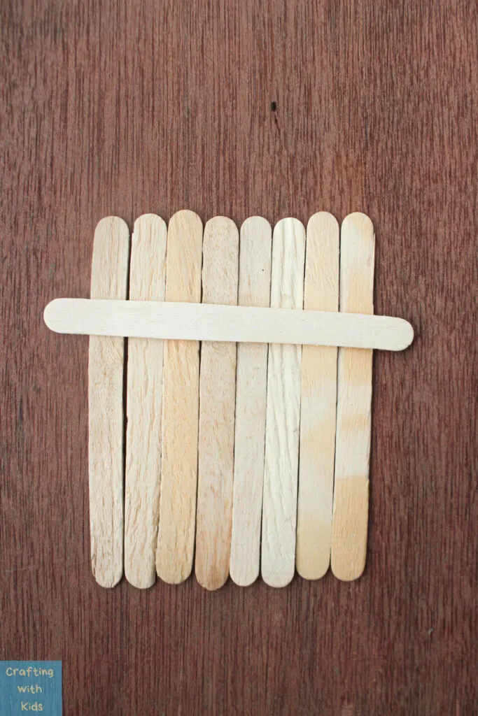 arranging popsicle sticks to make a fall craft