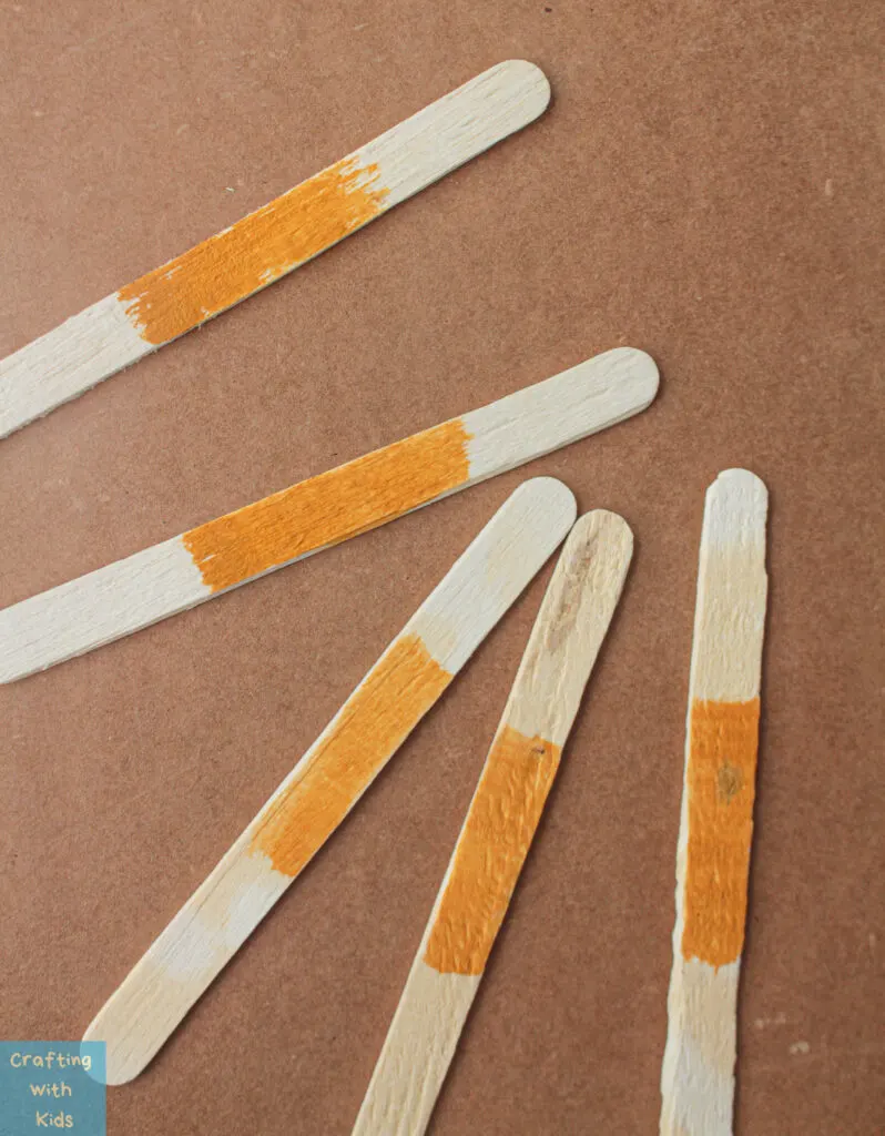 painting popsicle sticks orange