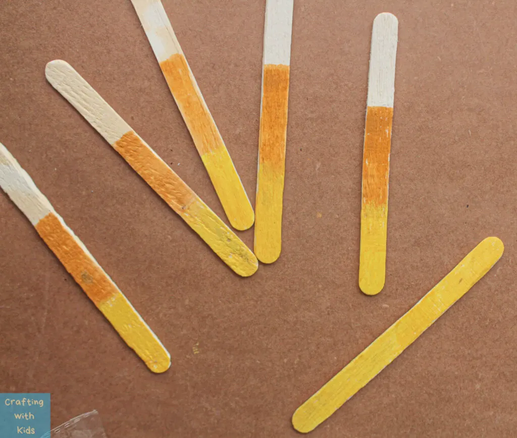 painting popsicle sticks to look like candy corn