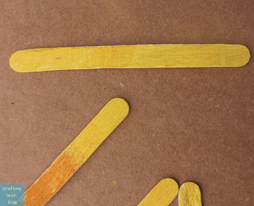painting popsicle sticks yellow