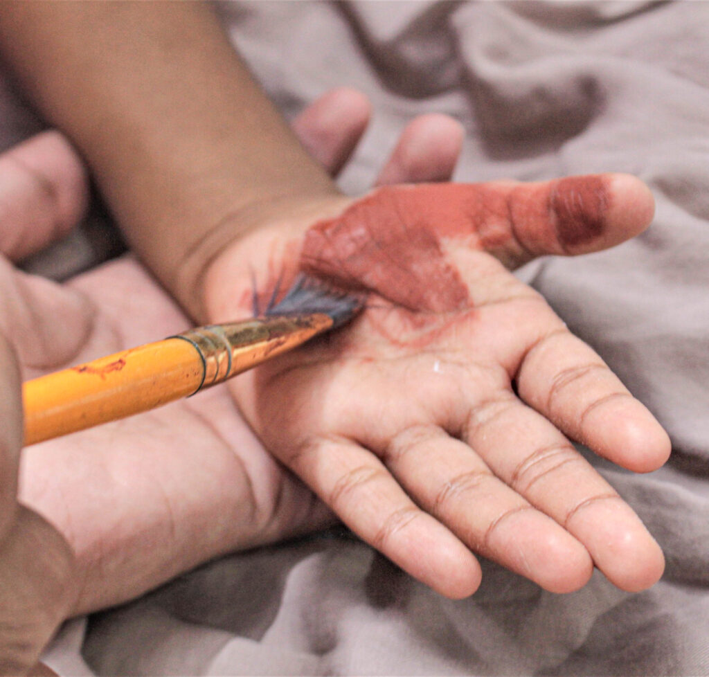 painting a child's hand for Turkey handprint art