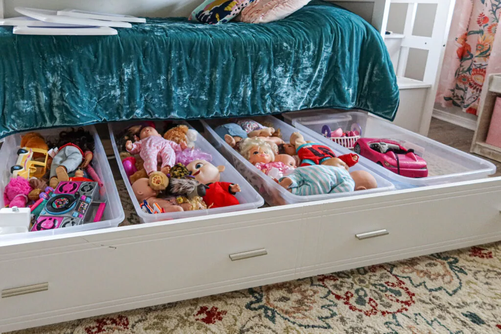 Under the bed storage idea with storage bins on a trundle