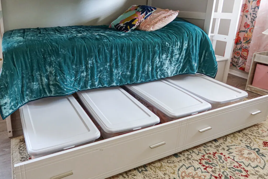 Under the bed storage idea with storage bins on a trundle