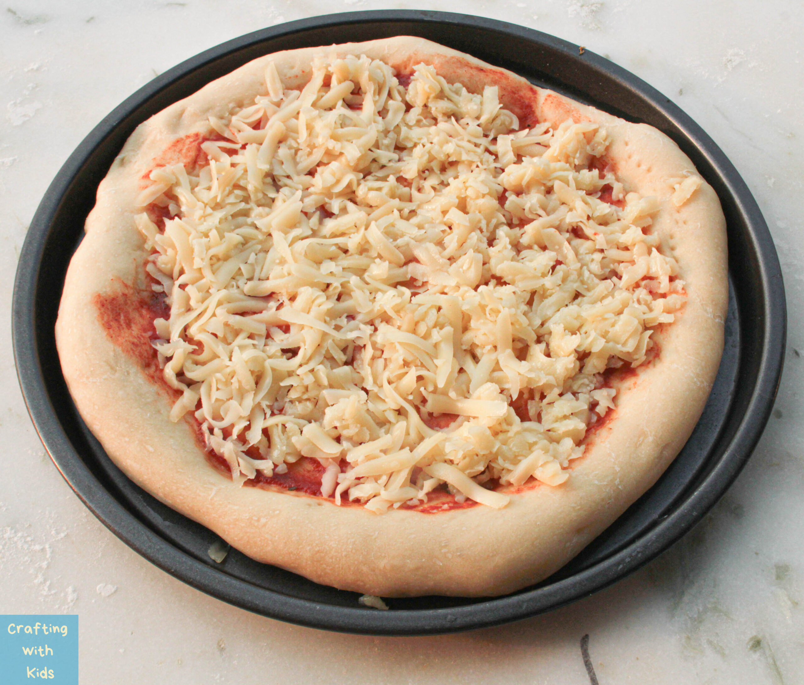 adding cheese to easy pizza with pillsbury pizza crust