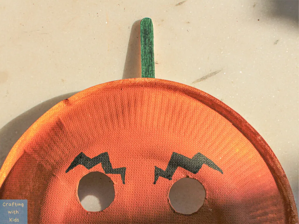 drawing eyebrows on paper plate pumpkin